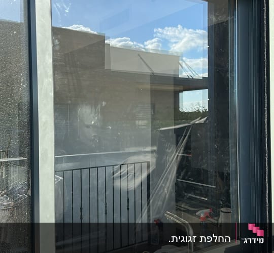 חלון זכוכית גדול במסגרת אלומיניום כהה